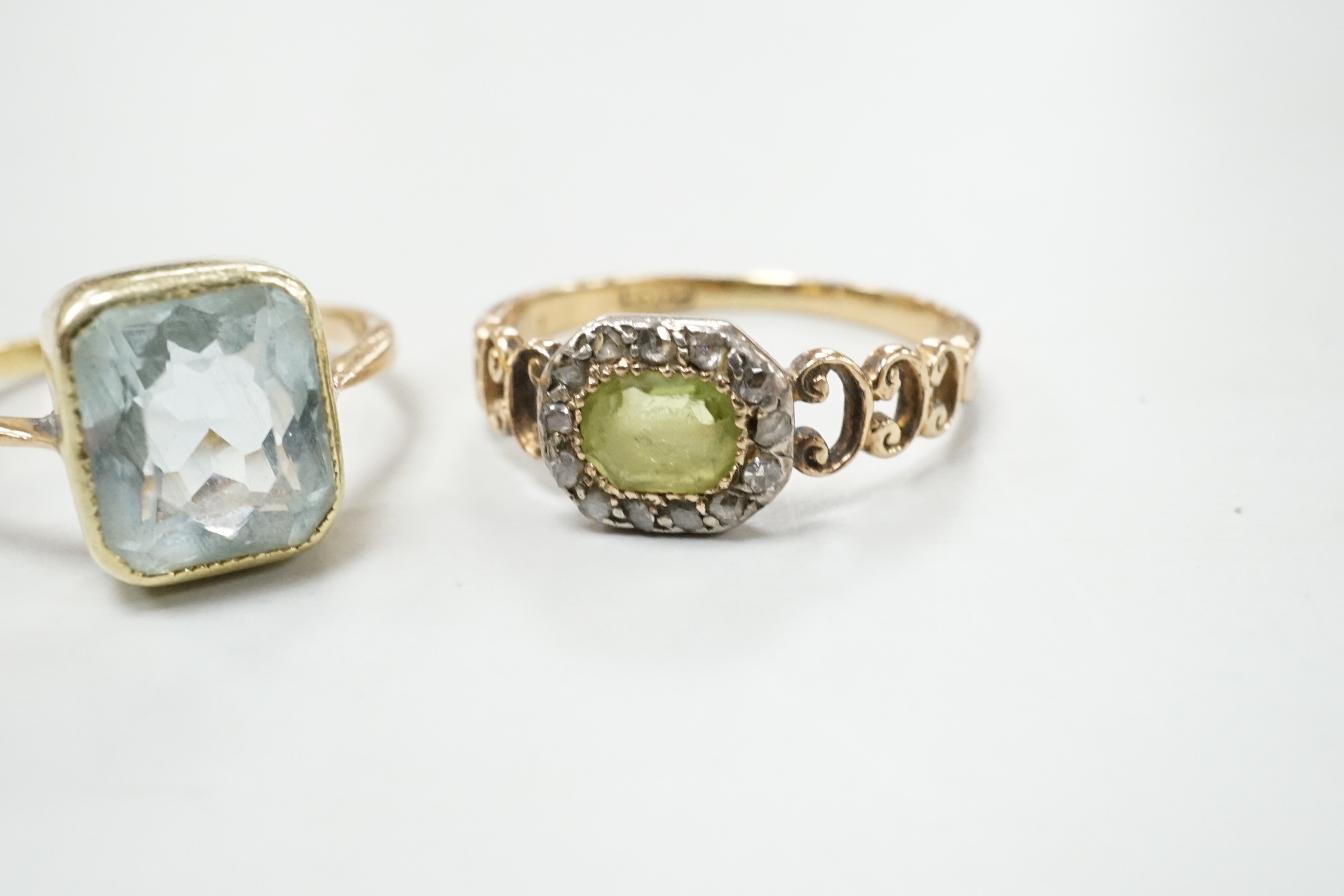 A late Victorian 15ct, peridot and diamond cluster set ring, size M and an Edwardian 15ct and aquamarine set ring, size K, gross weight 4.3 grams.